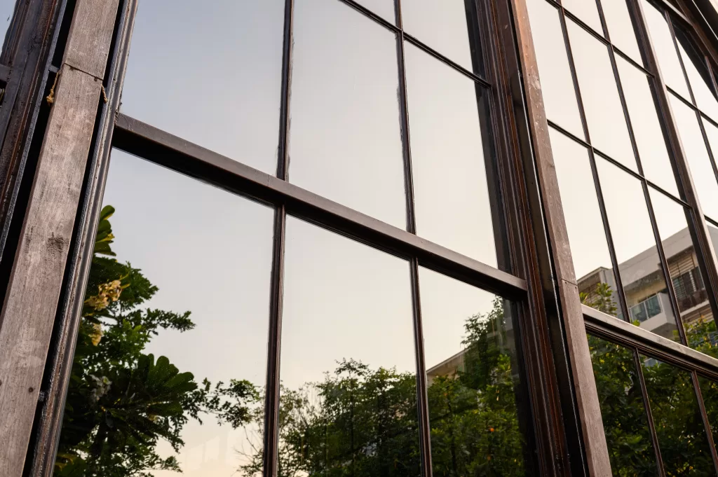 Tall windows reflecting trees and buildings in their glass panes.